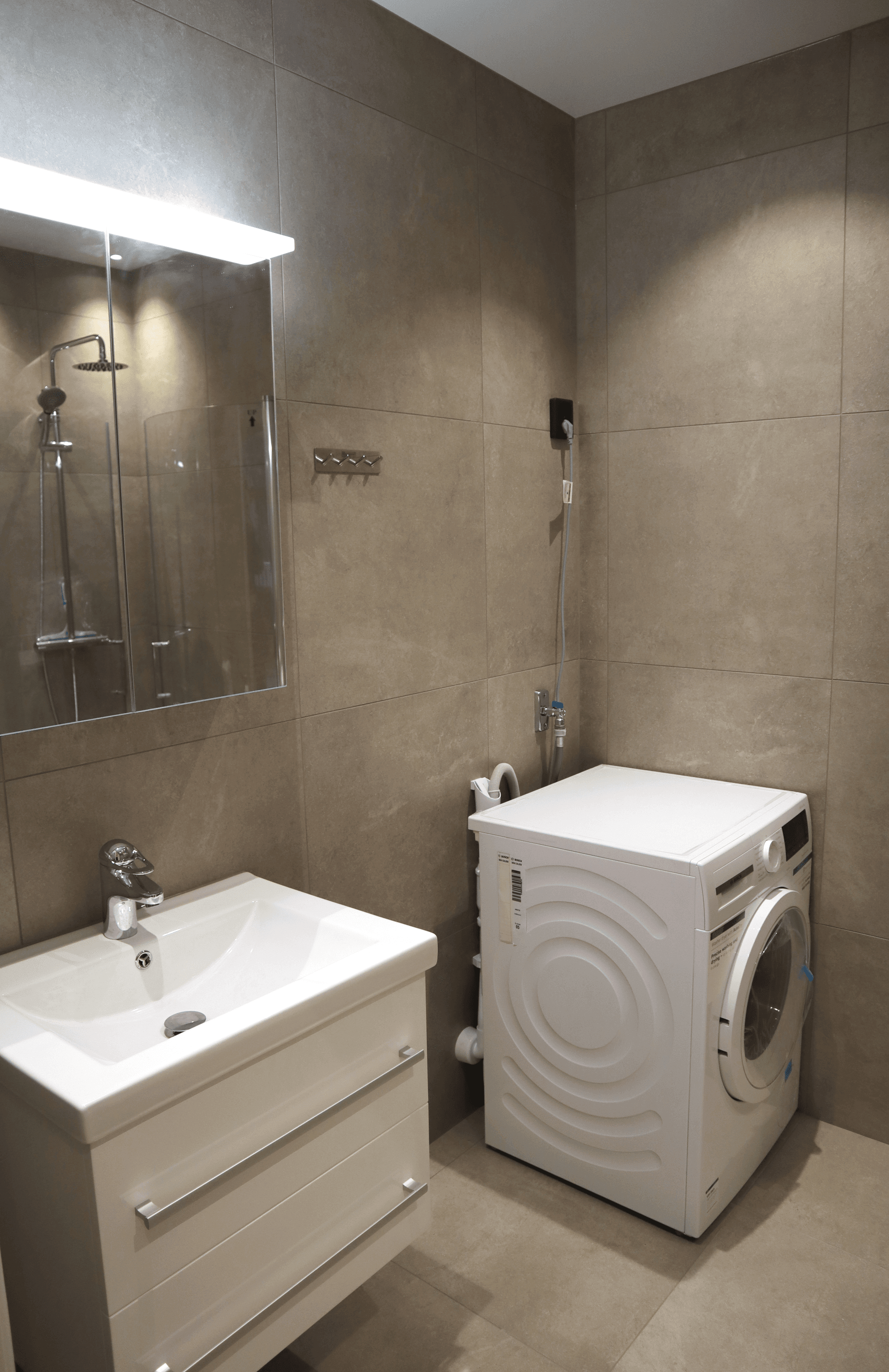 Tvättmaskin och tvättställ i lägenhet vid Villa Humlegården i Sundsvall